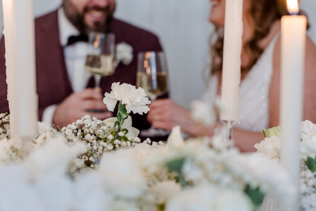 Brautpaar sitzt sich lächelnd bei Kerzenlicht gegenüber – intime Szene für einen emotionalen Hochzeitsfilm Dresden