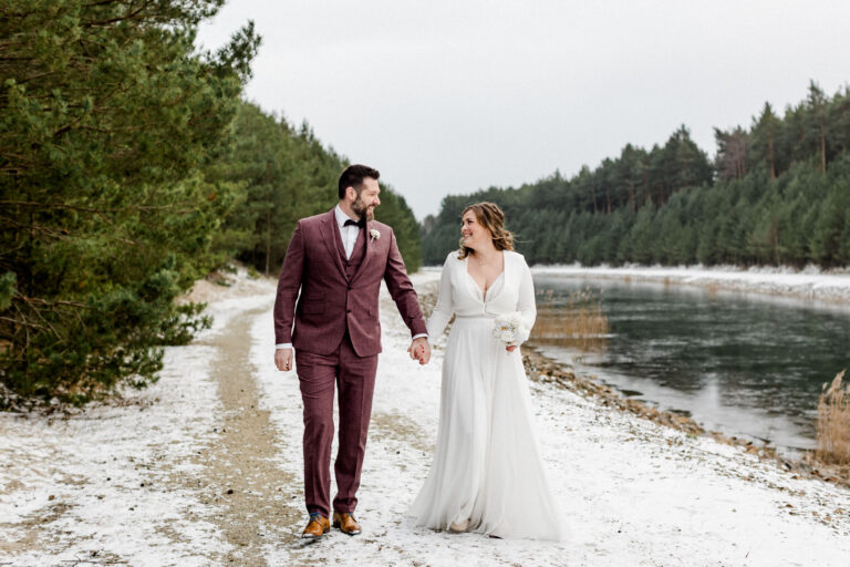 Braut und Bräutigam spazieren im Schnee – winterliche Hochzeit für einen Hochzeitsfilm in Dresden